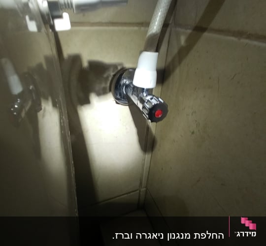 ברז מים עם צינור מחובר לקיר